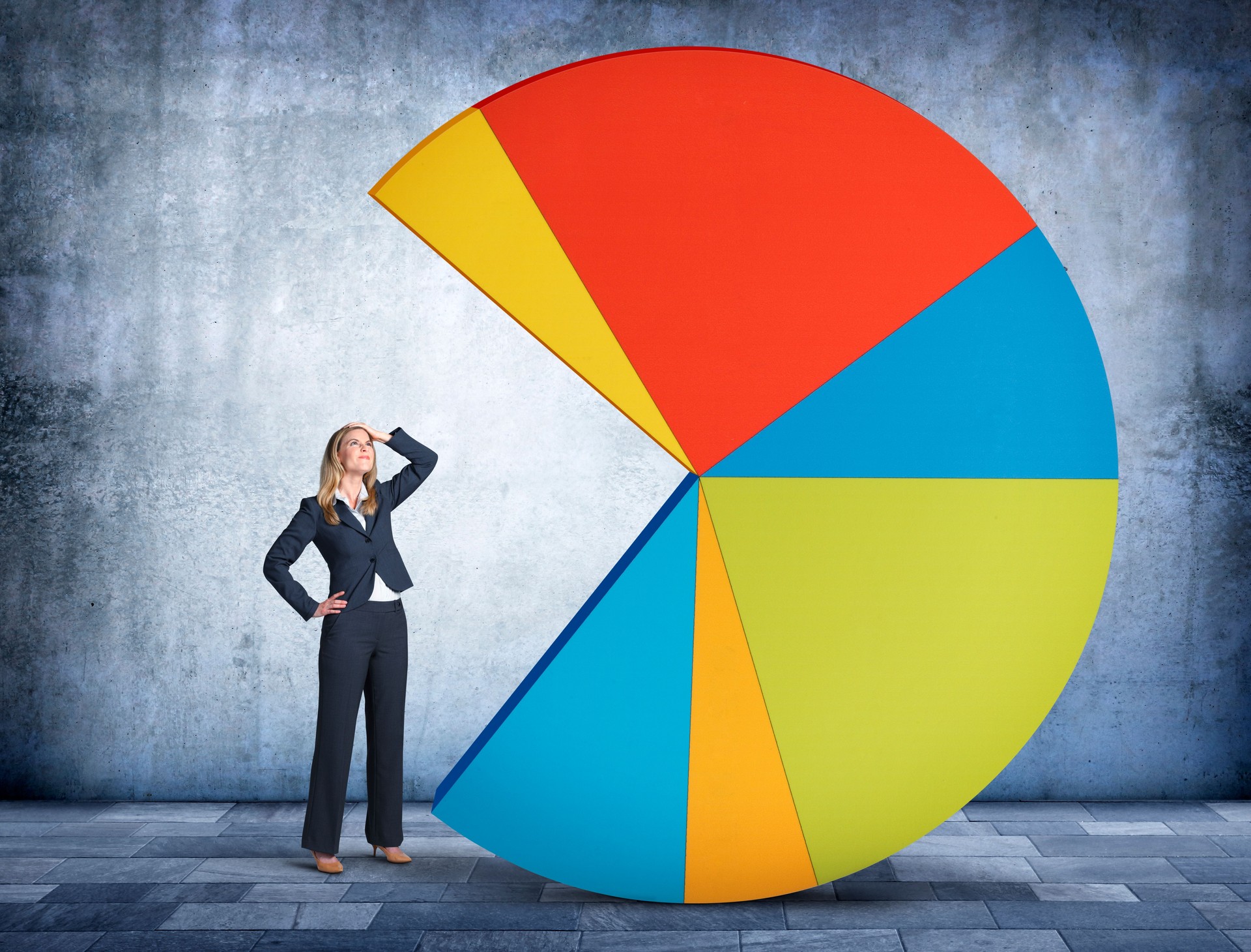 Businesswoman Looking Up At Pie Chart With Missing Piece